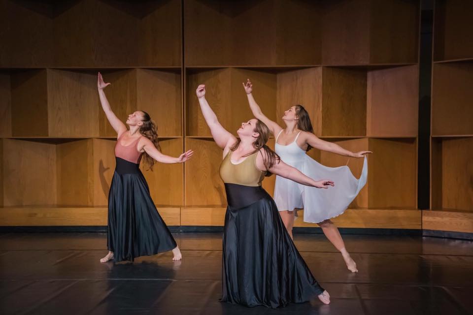 Symmetry Dance Company Adult Dance performance with three women on stage in flowing skirts