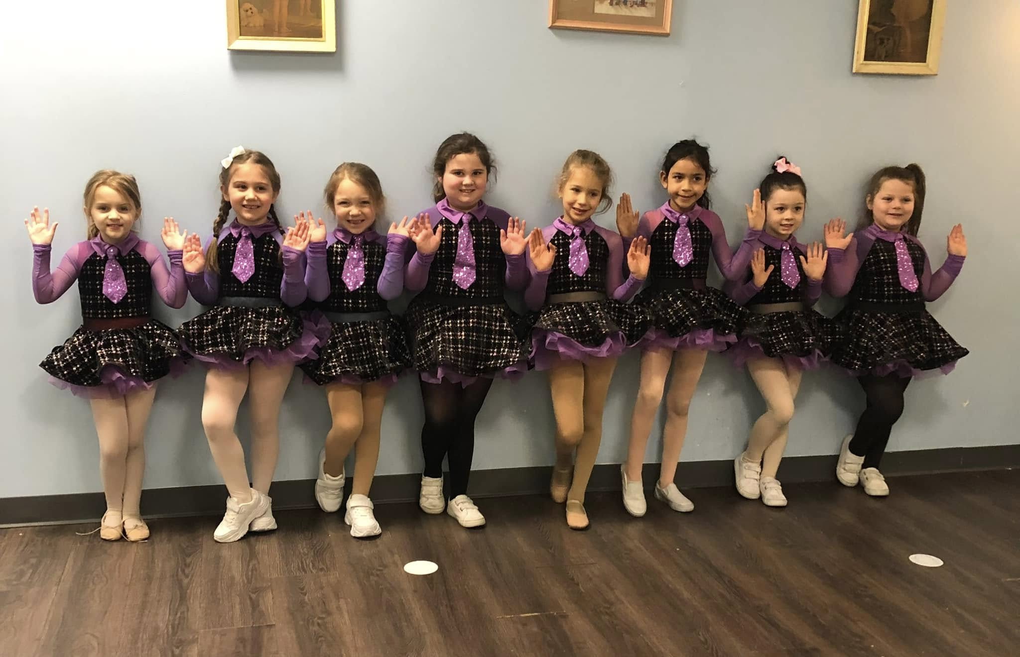Symmetry Dance Company Group Program students ages 4–10 in purple costumes smiling for class photo