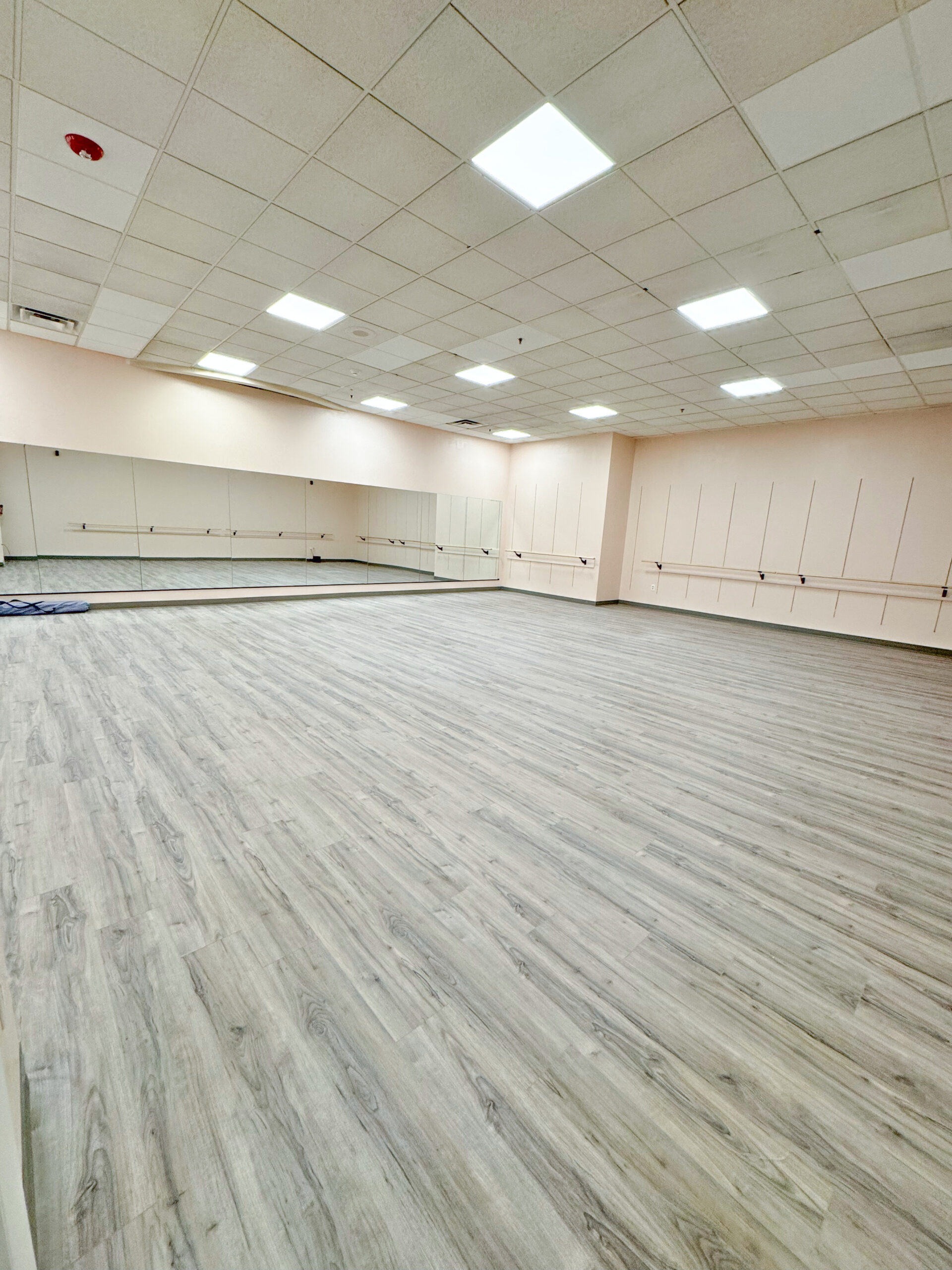 Symmetry Dance Company in Scranton PA's largest dance studio with ballet barres, full mirrors, and light gray flooring used for ballet, hip hop, and jazz classes.