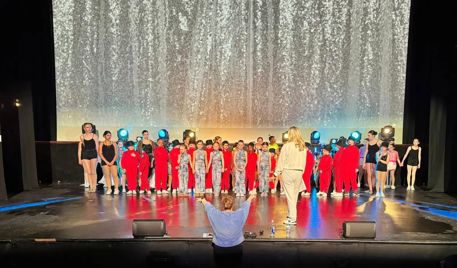 Group of Symmetry Dance Company students on stage during the spring recital finale in Scranton PA, showing kids and teens in costume.